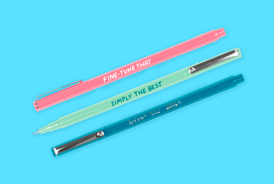 Two branded pink and green pens and one blue stylus on a blue background