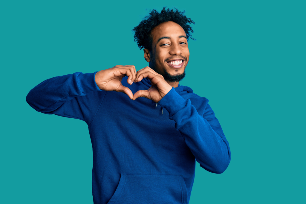 Man smiling and forming heart with hands